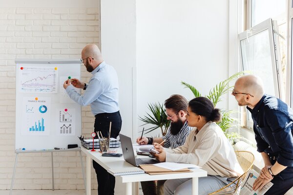 People in the office analysing data charts on a white board