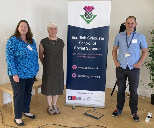 People standing by a banner reading 'Scottish graduate school of social science'